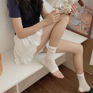 White ribbed stirrup leg warmers with vertical stripes in minimalist balletcore style