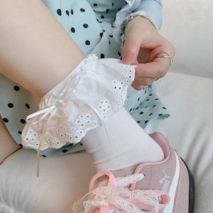 Detail view of white lace ruffles and ribbon bow on ballet style Lolita socks