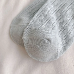 Detail of light blue mesh knit socks with breathable hollow pattern and delicate stitching