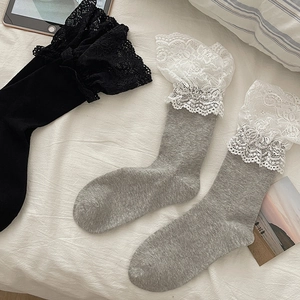 Detail of sweet Lolita style socks with delicate wide white lace trim and knitted texture