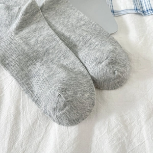 Gros plan sur la couture lisse et la texture tricotée fine de chaussettes grises