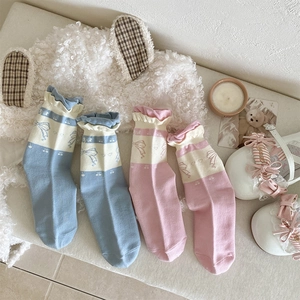 Detail of sweet bow and cherry patterns on frilly ribbed knit crew socks for girls