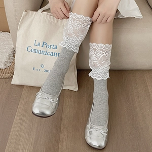 Detail of grey cotton mid-tube socks with elegant white floral lace trim and ballet flats
