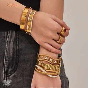 Detail shot of 18k gold plated chunky bracelets and rings on a model's wrist