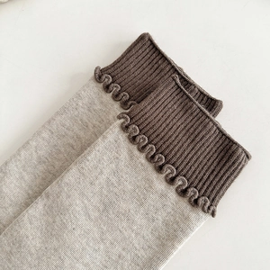 Détail rapproché du bord ondulé contrasté et de la texture côtelée sur les chaussettes