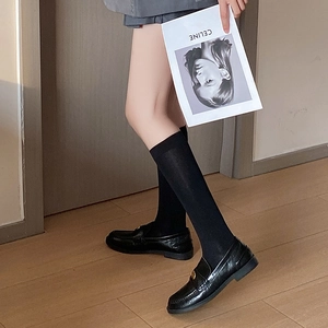 Classic black patent leather loafers with gold buckle and matching crew socks for women