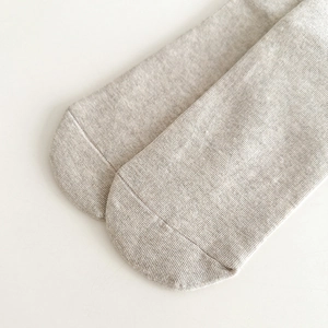 Détail de chaussettes en coton gris clair avec maille côtelée fine et coutures lisses aux pieds