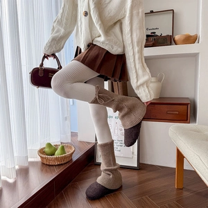 Detail of cable knit leg warmers in coffee brown with drawstring bow ribbons