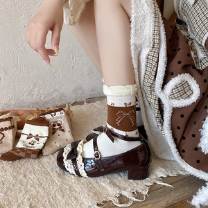 Detail of sweet brown bow socks with cherry print paired with Mary Jane shoes