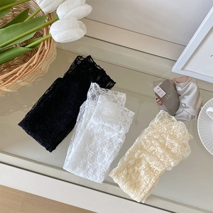Vue détaillée de chaussettes en dentelle délicate en noir, blanc et beige