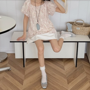 Dettaglio di calzini bianchi con pizzo abbinati a ballerine grigie con fiocco e gonna