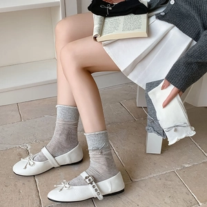 Detail of sweet bow charms and ruffled cuffs on mid-calf socks with Mary Jane shoes