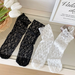Gros plan détaillé de chaussettes en dentelle ajourée noir et blanc avec motifs floraux
