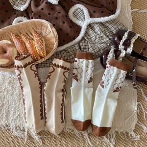 Flat lay detail of sweet Japanese style socks with lace edges, cherry and bow prints