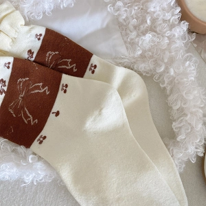 Detailed knit texture of vintage socks with cherry patterns and bow tie accents