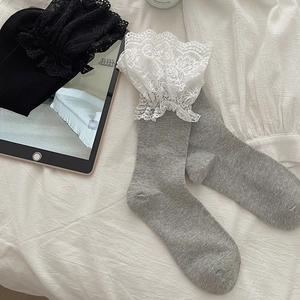 Close-up of elegant lace trim on grey and black Lolita calf socks with cotton texture