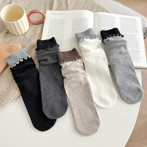 Détail de cinq paires de chaussettes mi-mollet à bords ondulés aux tons neutres