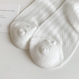 Gros plan détaillé de chaussettes en résille blanche avec motifs floraux et dentelle douce