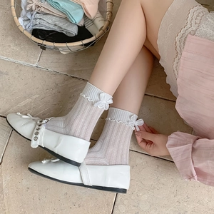 Detail of white rib-knit crew socks with feminine frill edges and cute back bow accents
