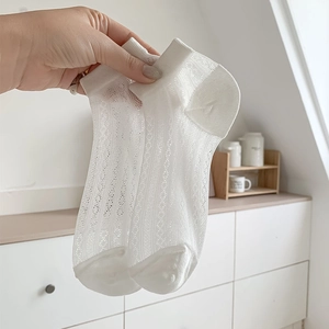 Détail de chaussettes en maille blanche avec découpes délicates et tricot de coton respirant