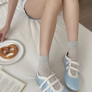 Minimalist light blue Mary Jane flats with white velcro straps in a cozy lifestyle setting