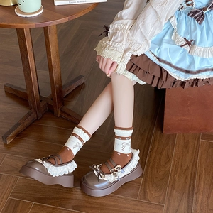 Detail of Lolita style brown Mary Jane shoes with lace trim and heart buckle bow socks