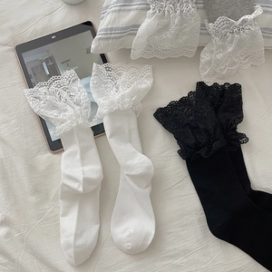 Detail of white and black Lolita socks with elegant lace trim and soft knitted texture