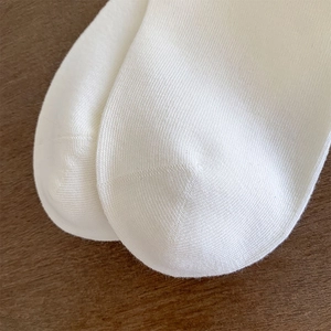 Close-up of knit texture and reinforced toe of white ballet style cotton socks