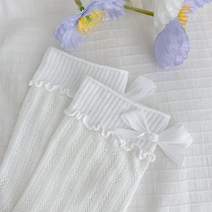 Detail of white hollow knit sock with delicate bow tie and frill cuff design