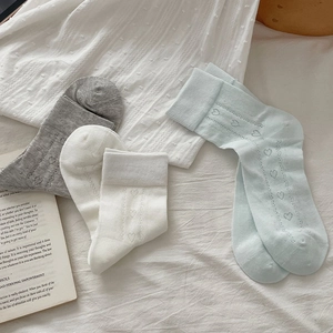 Detail of ballet style mesh socks with heart patterns in white, gray and light blue