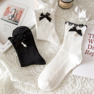Detailed view of Lolita style socks with lace ruffles, silk bows and pearl charms
