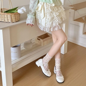 Gros plan sur chaussures Mary Jane blanches avec nœud et chaussettes en dentelle Lolita
