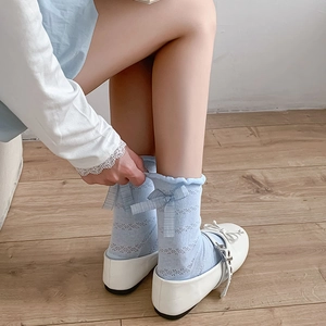 Detail of light blue mesh socks featuring a sweet ribbon bow and ruffled cuffs
