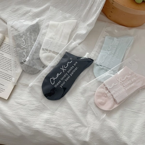 Detailed view of five pairs of heart-patterned mesh socks in pastel colors and packaging