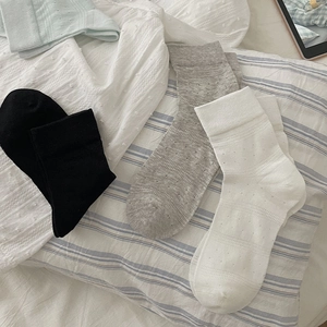 Detailed view of breathable mesh texture and ribbed cuffs on colorful mid-calf socks