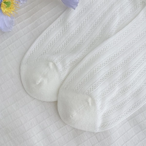 Detail of white mesh knit knee high socks with breathable vertical ribbing texture