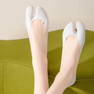 Nahaufnahme weißer Zehensocken für Damen, unsichtbares Design mit grünem Hintergrund