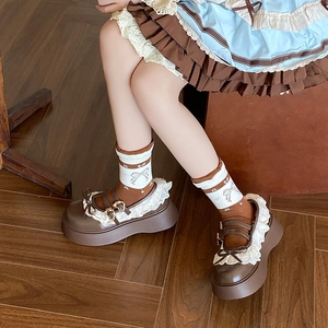 Detail of vintage Lolita socks with cherry patterns and lace trim on platform shoes