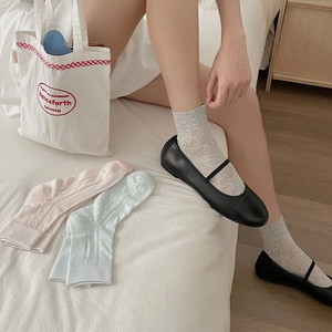 Detail of sweet ballet-style mesh socks with heart-shaped hollow patterns in pastel colors