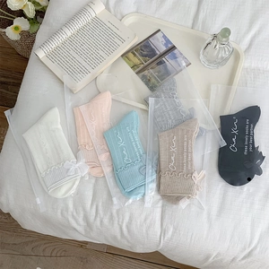 Detail of five pairs of bow-knot socks with frilly edges in assorted soft colors