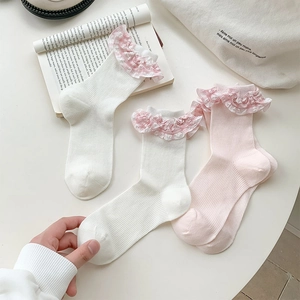 Close-up of ribbed cotton socks with lace edges and pink plaid lining in a soft layout