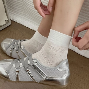 Detailed view of silver ballet sneakers with gray ribbons and white mesh socks