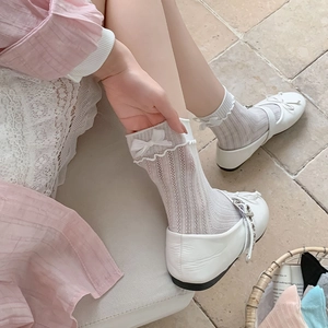 Close-up of white vertical striped socks with delicate lace trim and ribbon bow detail