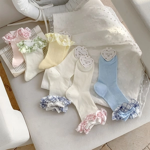 Detail of colorful cotton ruffled socks with plaid trim in five soft pastel colors