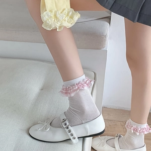 Close-up of gingham pattern ruffle socks paired with white bow Mary Jane shoes
