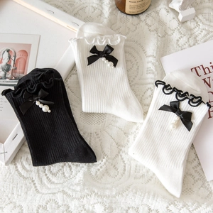 Detail of Lolita socks featuring silk bows, faux pearls, and delicate ruffled edges