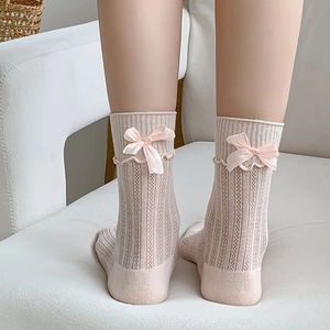 Close-up of pink mid-calf socks with vertical stripes and satin bow detail