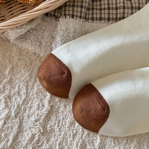 Detailed close-up of brown and cream contrast toe on high-quality knit crew socks