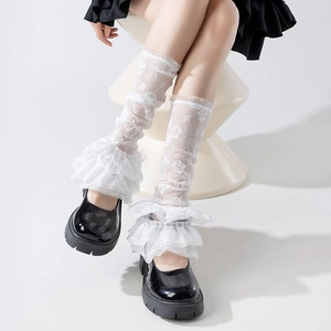 Detail of white lace leg warmer with multi-layer floral ruffles and intricate embroidery