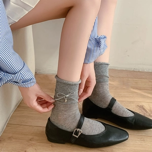 Women's grey cotton crew socks with blue ribbon bows and metallic heart pendants